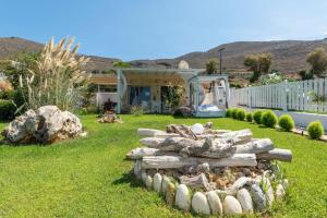 a yard with a pile of logs in the grass at Artemis Seafront Stone Studio in Petres +10 photos