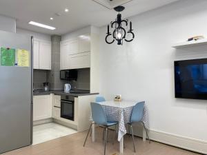 Una cocina con una mesa y sillas y una lámpara de araña. en ЖК Highvill Ishim D1, en Astana