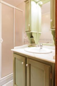 a bathroom with a sink and a mirror at Apartamento Otoño - Apartamentos Nature in Cangas del Narcea