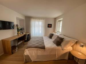 a bedroom with a bed and a desk with a computer at La torre in Belgirate