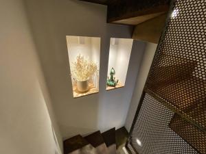 a room with two mirrors and a plant on a wall at La torre in Belgirate