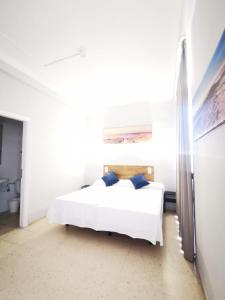 a bedroom with a white bed with blue pillows at Hotel Don Cándido in Puerto de la Cruz