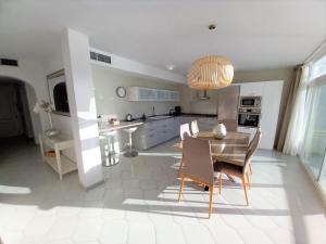 cocina y comedor con mesa y sillas en Miraflores Beachfront Penthouse, en Mijas Costa