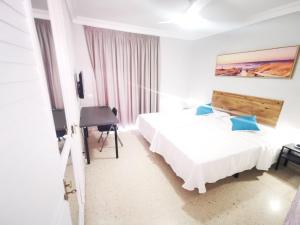 プエルト・デ・ラ・クルスにあるHotel Don Cándidoのベッド2台とデスクが備わるホテルルームです。