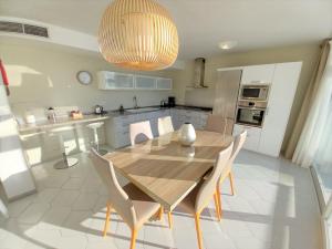 uma cozinha com uma mesa de jantar em madeira e cadeiras em Miraflores Beachfront Penthouse em Mijas Costa