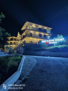 un gran edificio blanco con un cartel en él por la noche en Pine Clough Holidays Vagamon en Vagamon