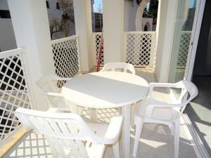a white table and white chairs on a porch at AL101 apartamento, céntrico y piscina in Alcossebre