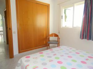 a bedroom with a bed and a chair and a window at AL101 apartamento, céntrico y piscina in Alcossebre +21 photos