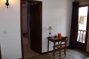 Habitación con mesa y puerta que conduce a un dormitorio. en maison de marie en Doussard
