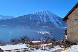 a snow covered mountain in front of a building at Maison de village au cœur du hameau Les Marches à Orcières in Orcières +3 photos