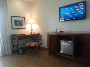 a room with a desk and a television on the wall at Hotel & Spa Hacienda de Cortés in Cuernavaca