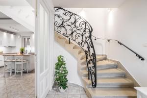 a staircase with a black and white wrought iron railing at Villa Suburbia Budapest in Budapest