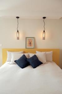 um quarto com uma cama branca e 3 almofadas em Domaine Labouroume em Salies-de-Béarn