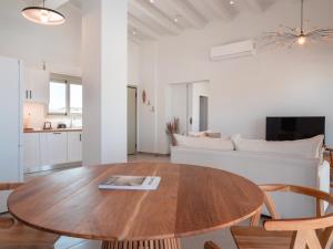 un soggiorno con tavolo in legno e divano di Alykes Beachside Stylish Villas with Private Pool South Rhodes a Lakhania