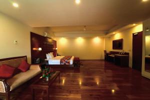Habitación de hotel con cama y sofá en The Allure Grand Resort - A Riverside Resort and Spa, en Manali