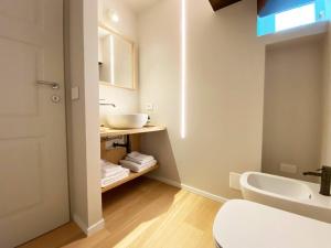 a white bathroom with a sink and a toilet at La Torre - Luxury Rooms - Belgirate in Belgirate +84 photos