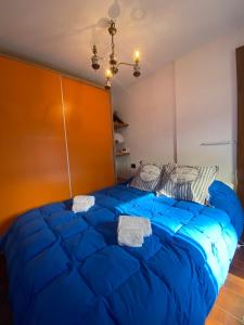 a large blue bed in a bedroom with a large headboard at Hostdomus - Grand Villard Suite in Sauze d'Oulx