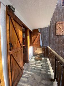a room with wooden doors and a table and chairs at Hostdomus - Grand Villard Suite in Sauze d'Oulx