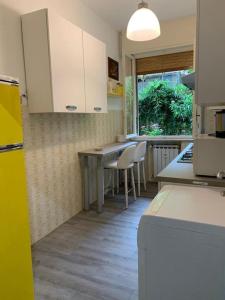 een keuken met witte kasten en een tafel en stoelen bij House Il Glicine in Santa Margherita Ligure