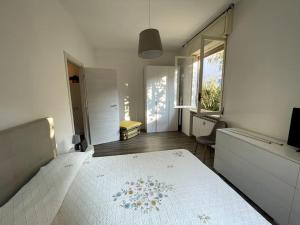 een slaapkamer met een bed met een witte sprei en een raam bij House Il Glicine in Santa Margherita Ligure