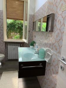 een badkamer met een wastafel en een spiegel bij House Il Glicine in Santa Margherita Ligure