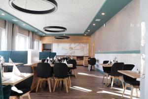 una sala da pranzo con tavoli, sedie e schermo di Hotel Restaurant Haus Zwicker a Bleialf