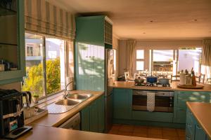 a green kitchen with a sink and a window at Hermanus Family Getaway - Near The Beach in Hermanus