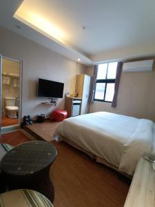 1 dormitorio con 1 cama grande y TV en Fu Yu Spring House, en Baihe