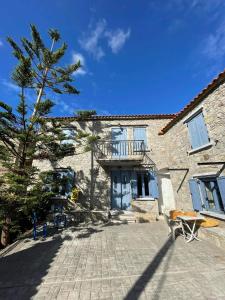 um grande edifício de pedra com uma árvore em frente em Kontias stonehouse 2 em Kondiás