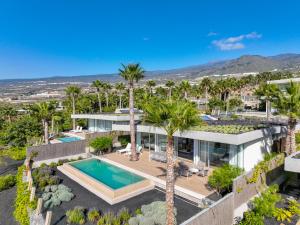 an aerial view of a house with a swimming pool and palm trees at Los Jardines de Abama Suites in Guía de Isora