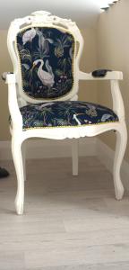 a white chair with a floral seat in a room at Àit Sèan Òg - 2bedroom self catering apartment 