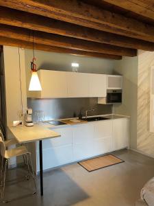 uma cozinha com armários brancos e uma mesa em City Live em Rovigo