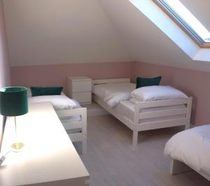 a attic bedroom with two beds and a skylight at Àit Sèan Òg - 2bedroom self catering apartment 