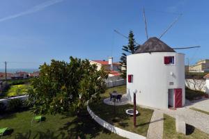 una piccola casa bianca con tetto nero di FLH Moinho do Mar a Ericeira