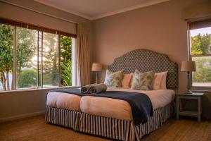 a bedroom with a large bed with a large window at Hermanus Family Getaway - Near The Beach in Hermanus