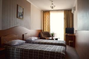 ストルィーにあるHotel Perlyna ARSのベッドと椅子付きのホテルルーム