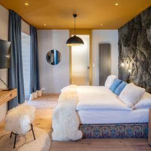 a bedroom with a large white bed with furry pillows at Oblík Resort in Louny