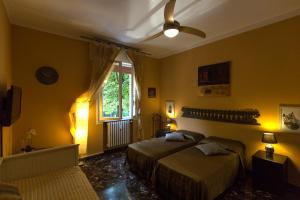 a bedroom with two beds and a ceiling fan at B&B ARCOVEGGIO in Bologna