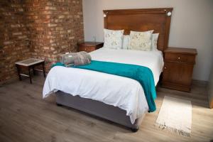 1 dormitorio con 1 cama grande y cabecero de madera en Opstal Guestfarm, en Potchefstroom