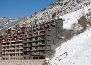 un edificio al lado de una montaña nevada en THE MIRROR & SPA by Elegant Residences, en Ransol