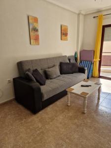 een woonkamer met een bank en een salontafel bij Costamarina Apartments in Cabo Roig