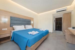 a bedroom with a blue bed and a sink at Marathon Hotel - All Inclusive in Kolymbia