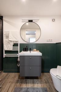 a bathroom with green walls and a sink and a mirror at E41- Boutique Apartments, Best Location, by BQA in Budapest