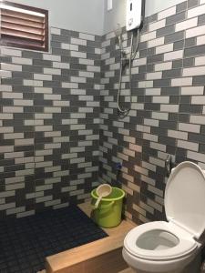 a bathroom with a toilet and a shower at Mountaindew Garden and Pool in Roxas
