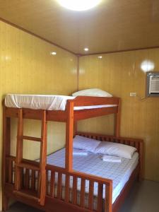 two bunk beds in a room with a fan at Mountaindew Garden and Pool in Roxas