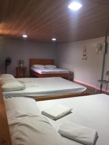 um quarto com três camas num quarto em Mountaindew Garden and Pool em Roxas