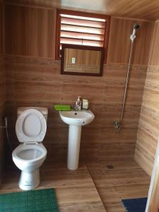 a bathroom with a toilet and a sink at Mountaindew Garden and Pool in Roxas