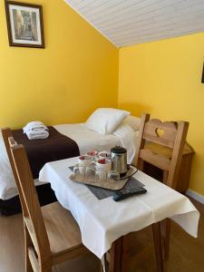 a room with two beds and a table with a tray of food at Hôtel du Château in Annecy