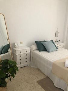 sypialnia z łóżkiem, lustrem i komodą w obiekcie VILLA SALMONETE w mieście Sanlúcar de Barrameda