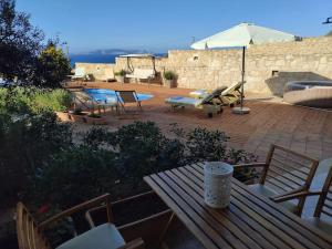 カルテロスにあるPamela's house "private pool and spa"の木製ベンチとパラソル付きのパティオ